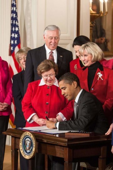 A photo of Barack Obama signing legislation that enforces/encourages equal pay.