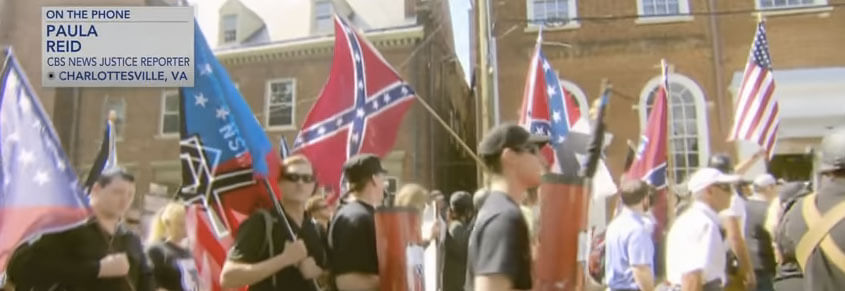 A photo from the Unite the Right rally in Charlottesville. White men are carrying Confederate flags.