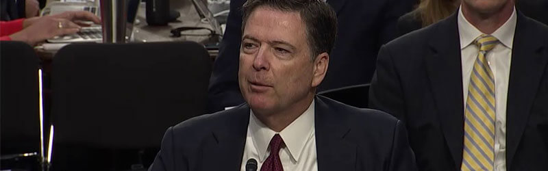 A photo of James Comey testifying at a hearing.
