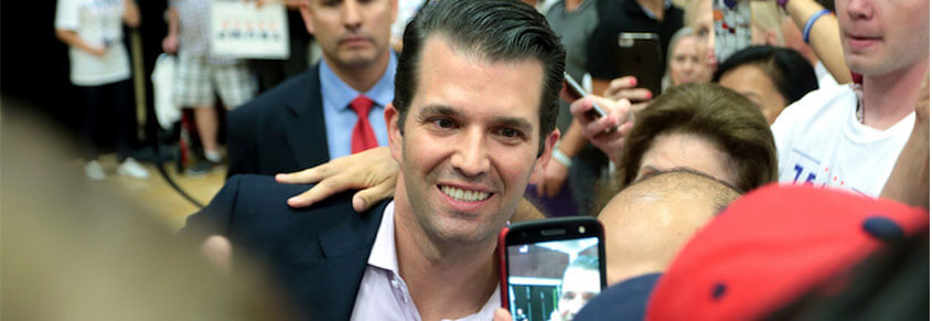A photo of Donald Trump Jr taking a photo with someone in a crowd.