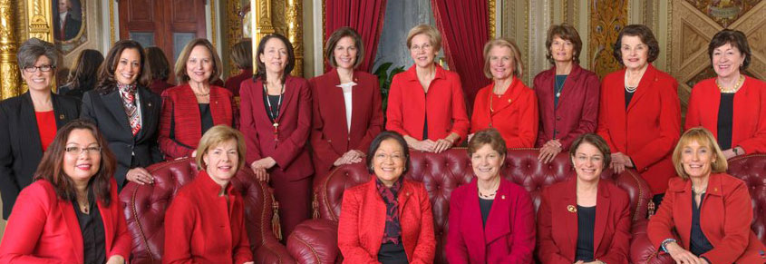 A photo of female Democratic politicians, largely dressed in red jackets.