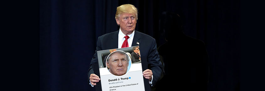 A photo of Donald Trump holding up a sign with his Twitter profile on it.