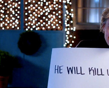 A photo of Kate McKinnon holding up a sign that says, "He Will Kill Us All"