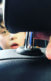A photo of a young white boy in the back of a car.