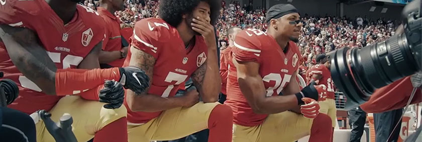 A photo of Colin Kaepernick kneeling with some teammates