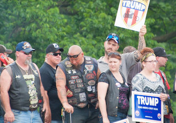 A photo of Trump supporters with signs like "Hillary For Clinton 2016"