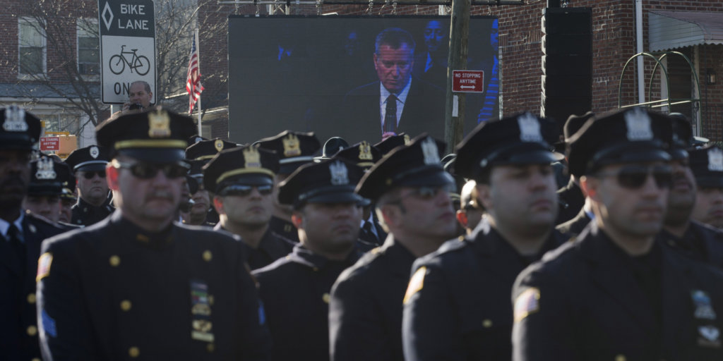 Police officers turn their backs as New York City Mayor Bill de Blasio speaks at the funeral of New York city police officer Rafael Ramos in the Glendale section of Queens, Saturday, Dec. 27, 2014, in New York. Ramos and his partner, officer Wenjian Liu, were killed Dec. 20 as they sat in their patrol car on a Brooklyn street. The shooter, Ismaaiyl Brinsley, later killed himself.