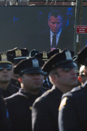 Police officers turn their backs as New York City Mayor Bill de Blasio speaks at the funeral of New York city police officer Rafael Ramos in the Glendale section of Queens, Saturday, Dec. 27, 2014, in New York. Ramos and his partner, officer Wenjian Liu, were killed Dec. 20 as they sat in their patrol car on a Brooklyn street. The shooter, Ismaaiyl Brinsley, later killed himself.