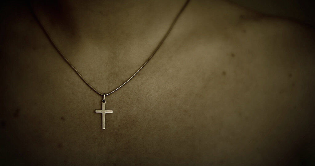 A photo of someone wearing a cross necklace