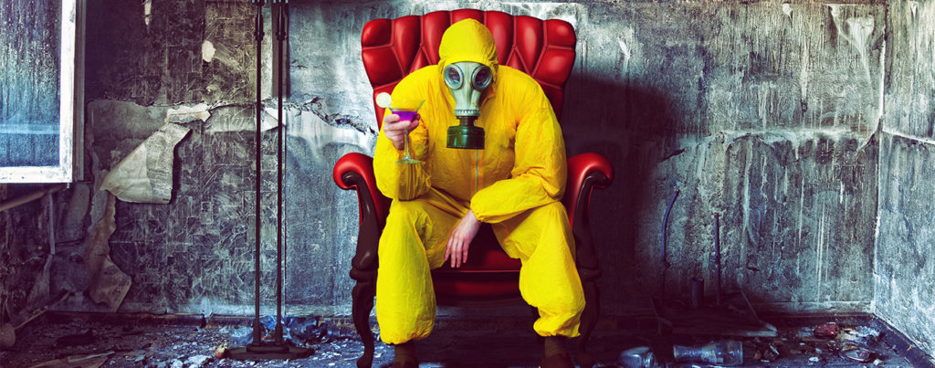 A photo of someone in a hazmat suit holding a cocktail.