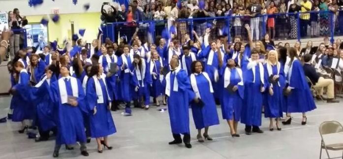 A photo of high school students at their graduation throwing their caps in the air