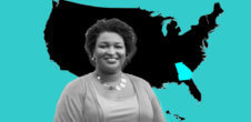A photo of Stacey Abrams in front of a map of the United States which is black, except the state of Georgia is blue.