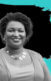 A photo of Stacey Abrams in front of a map of the United States which is black, except the state of Georgia is blue.