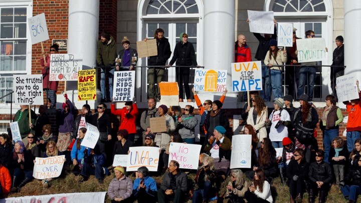 People gather with signs during a protest at the Phi Kappa Psi fraternity house at the University of Virginia in Charlottesville on Saturday, Nov. 22, 2014. The University of Virginia on Saturday suspended activities at all campus fraternal organizations amid an investigation into a published report in which a student described being sexually assaulted by seven men at a fraternity in 2012.
