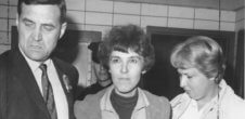 A photo of Valerie Solanas after she had been arrested. A police officer is in the background.