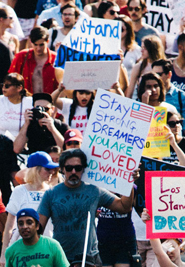 A photo from a protest support DACA. Posters have messages like "United and Strong," "Stay Strong Dreamers. You Are Loved And Wanted," and "Los Angeles Stands With Dreamers."