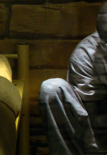 A still from the Black Mirror episode “Black Museum,” featuring a Black man sitting on the ground.