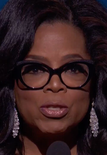 Oprah Winfrey speaking on stage at the Golden Globes