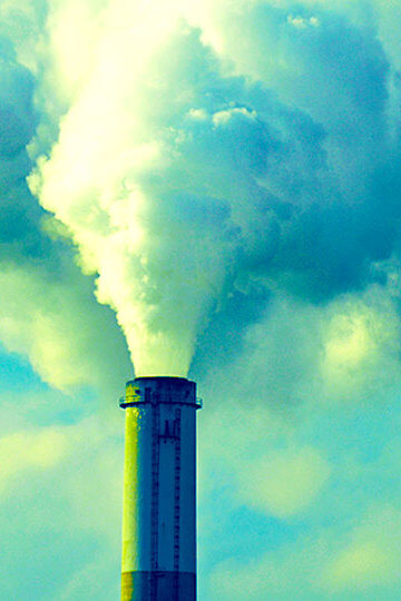 A photo of smoke coming out of factory chimneys