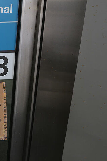 A photo at an airport near an arrivals point. There is a sign that says "America=Immigrants"