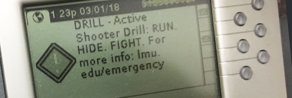 A message on a machine that says, "Drill – Active. Shooter Drill: Run. Hide. Fight. For more info: Imu.edu/emergency