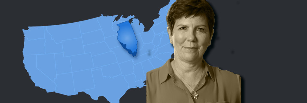 A photo of Becky Anderson Wilkins in front of a map of the United States. The state of Illinois sticks out.