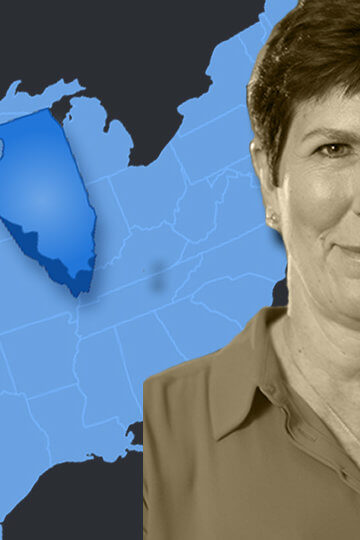 A photo of Becky Anderson Wilkins in front of a map of the United States. The state of Illinois sticks out.