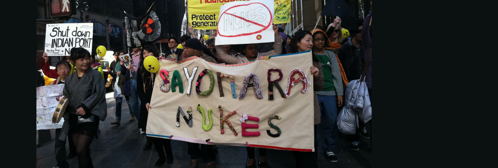 A photo of a protest. A sign that says 'Sayonara Nukes" is mostly visible.
