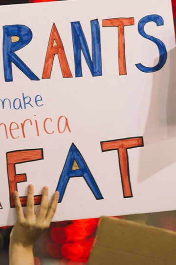 Signs from a protest, and two say "Immigrants Make America Great" and "No Hate No Fear Refugees are Welcome Here"