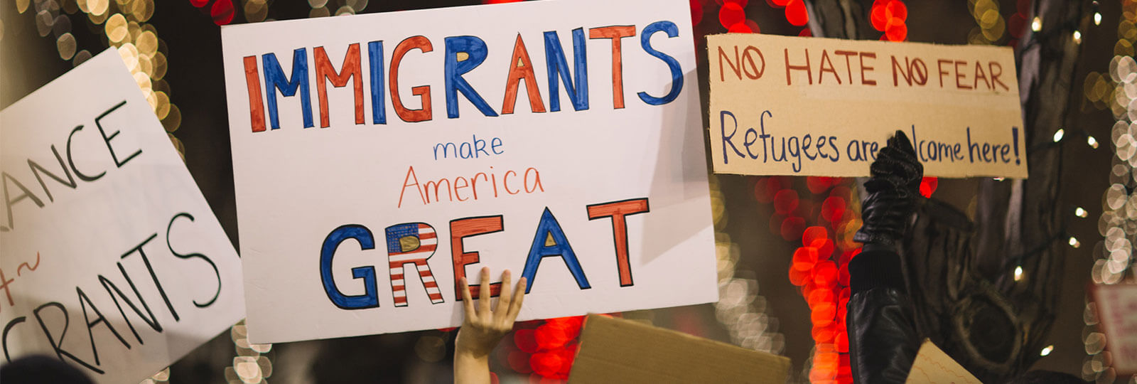Signs from a protest, and two say "Immigrants Make America Great" and "No Hate No Fear Refugees are Welcome Here"