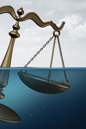 An illustration of the scales of justice going underwater