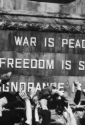 A photo of people in front of a monument that says "War is peace. Freedom is slavery."