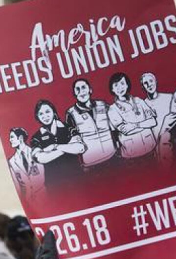 A photo from a protest at the White House. A pamphlet is visible with the text, "America Needs Union Jobs."