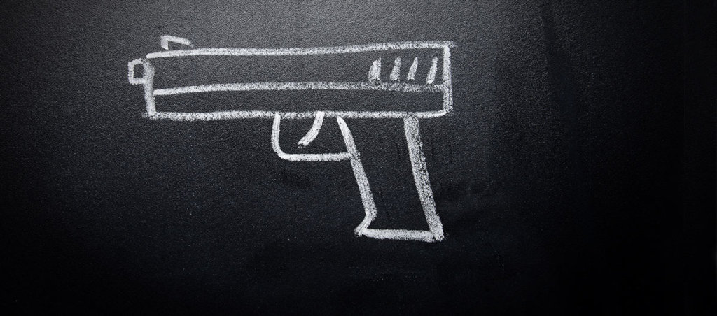 A photo of a gun drawn on a chalkboard