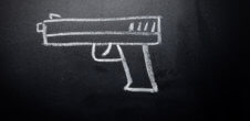 A photo of a gun drawn on a chalkboard