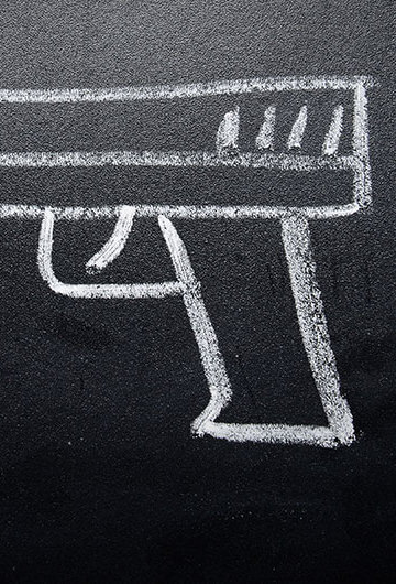 A photo of a gun drawn on a chalkboard
