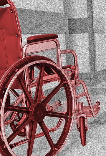 A photo of a wheelchair in a hospital hallway.