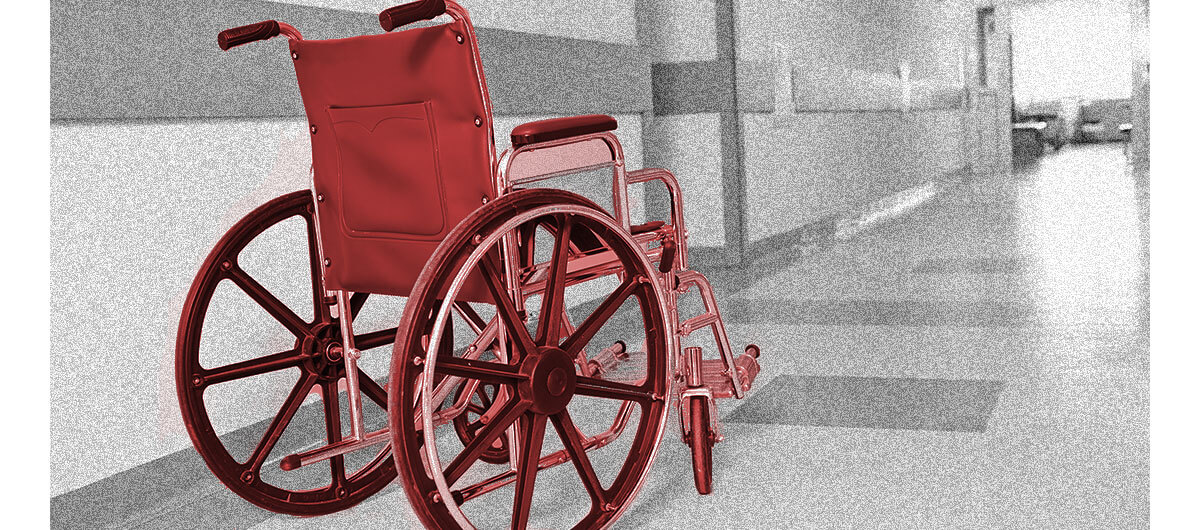 A photo of a wheelchair in a hospital hallway.