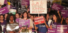 A photo from an abortion rights protest where people, largely women, are holding signs with messages like "Protect Roe" and "#SaveSCOTUS"