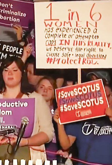 A photo from an abortion rights protest where people, largely women, are holding signs with messages like "Protect Roe" and "#SaveSCOTUS"