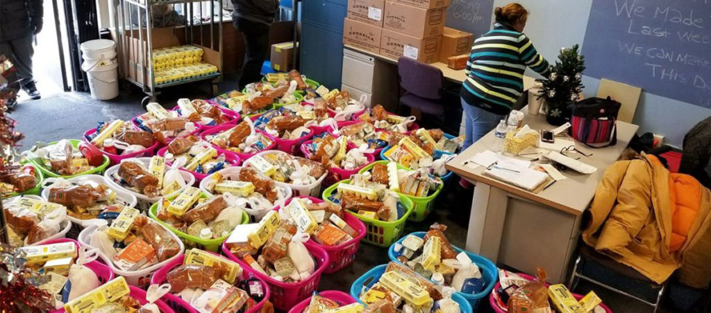 A photo of prepared baskets of food. One woman is likely preparing another in the background.