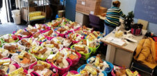 A photo of prepared baskets of food. One woman is likely preparing another in the background.