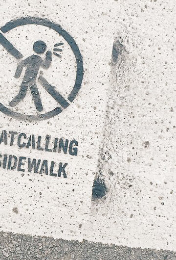 A photo of a sign that ays, "No catcalling on the sidewalk"