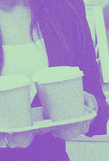 A photo of an intern carrying coffee at an office.