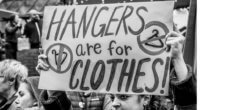 A photo from a protest with a sign that says "Hangers are for Clothes."