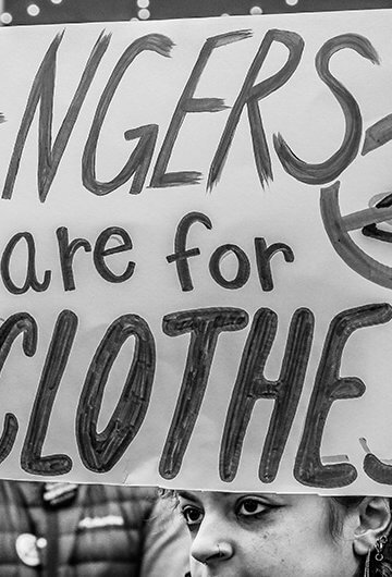 A photo from a protest with a sign that says "Hangers are for Clothes."