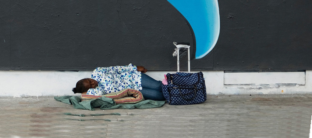 A photo of a Black person lying on a blanket outside.