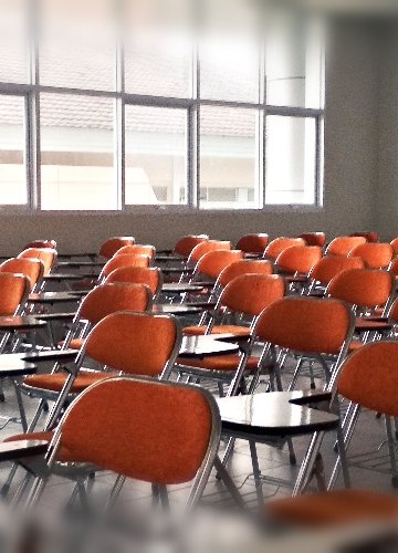 A photo of a classroom with chairs with desks being attached to them.