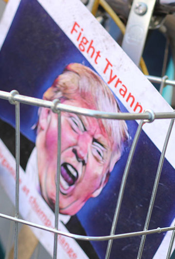 A picture of a bike cart with a sign that says "Fight Tyranny" with an illustration of Donald Trump in it.