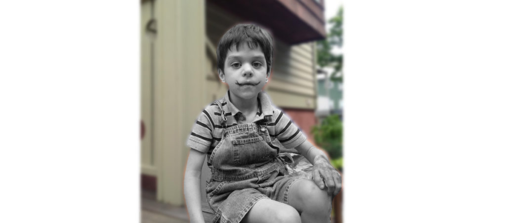 A photo of a young kid sitting outside.